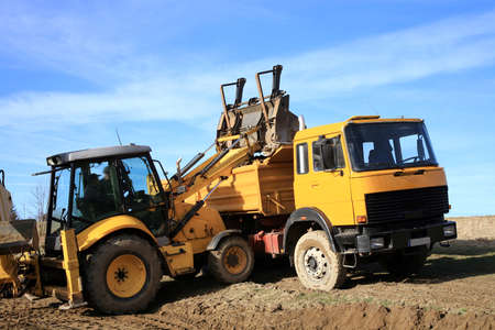 Excavator loads the ground in the truck   The construction of a new road 
