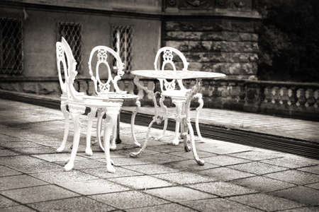 Old forgotten garden table and chairs on a deserted castle terrace.の写真素材