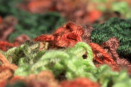 Close up green, red and brown yarn thread as abstract background with selective focus.の写真素材