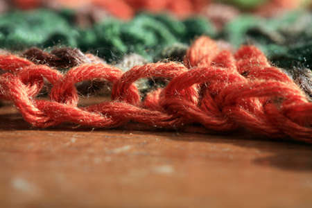 Close up green, red and brown yarn thread as abstract background with selective focus.