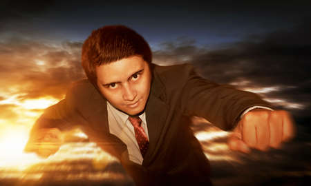 Businessman flying at sky sunsetの写真素材