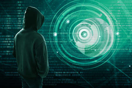 Hacker standing over a screen with binary code