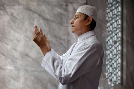 Old muslim man praying in mosqueの写真素材