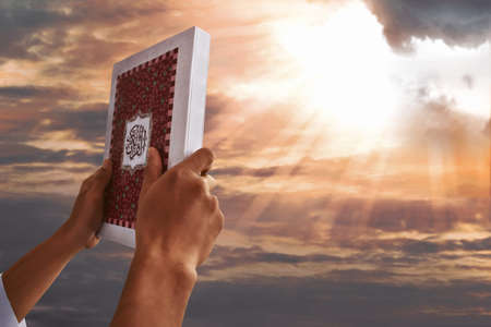 Muslim man hands holding koran