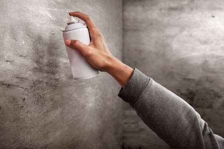 Hand holding a spray can