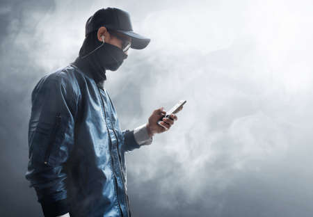 Hacker holding a phoneの写真素材