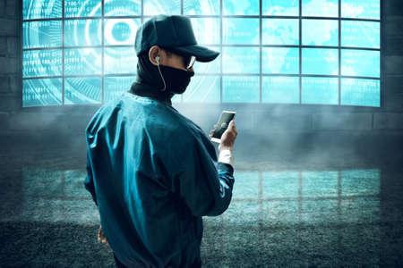 Hacker holding a phoneの写真素材