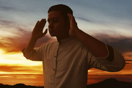 Silhouette of muslim man praying