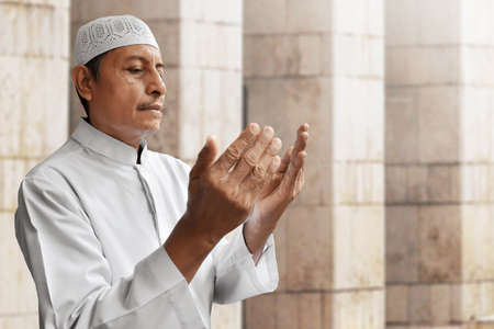 Old muslim man praying in mosque