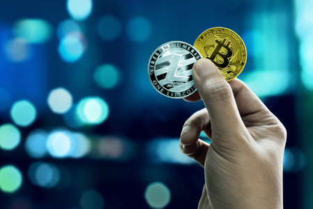Hand holding bitcoin and litecoin coinsの写真素材