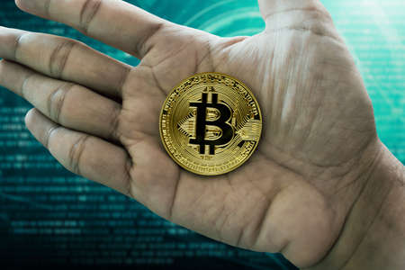 Hand holding golden bitcoin