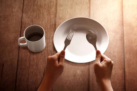 Empty plate on wooden table, Fasting concept