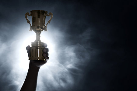 Man holding golden trophy cupの写真素材