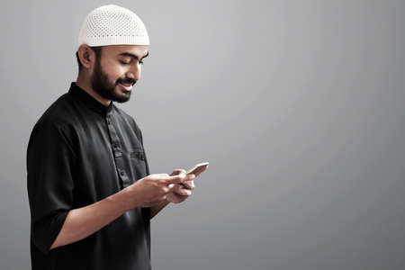 Religious asian muslim man use handphoneの写真素材
