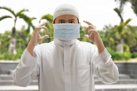 Religious asian muslim man wearing medical maskの写真素材