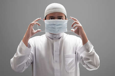 Religious asian muslim man wearing medical maskの写真素材