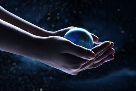 Human hand holding planet earth