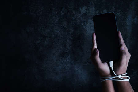 Hand holding smartphone; addiction conceptの写真素材