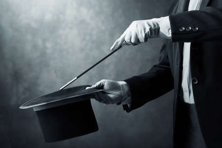 Magician hand holding magic wand on dark backgroundの写真素材