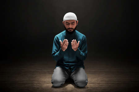 Muslim man greeting on dark backgroundの写真素材