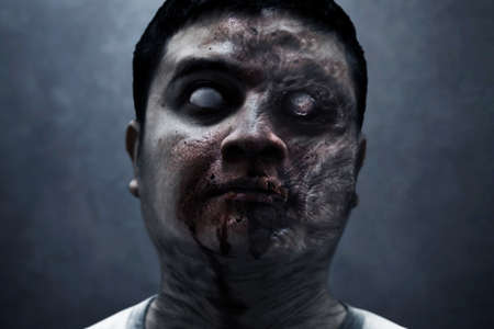 Scary zombie man on dark backgroundの写真素材