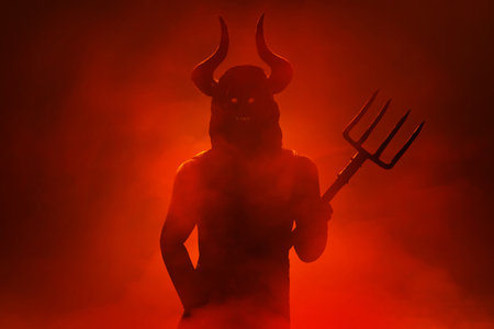 Scary devil silhouette holding pitchfork trident in hell with smoke mist fog, Halloween themeの写真素材