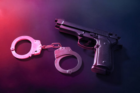 Gun and handcuffs on dark smoke backgroundの写真素材