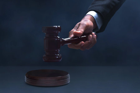 Judge hand striking gavel on dark smoke backgroundの写真素材