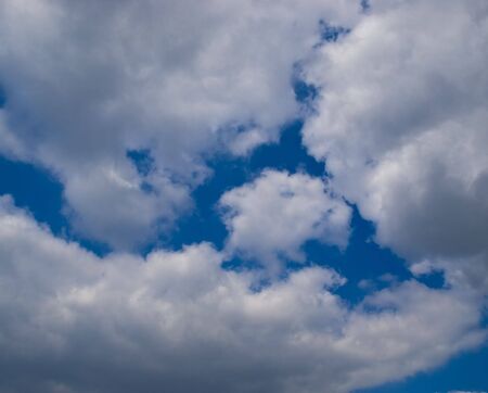 The big white clouds against the dark blue sky