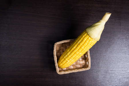 Corn on basket on wood background.の写真素材