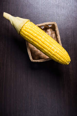 Corn on basket on wood background.の写真素材