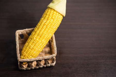 Corn in basket on wood background.の写真素材