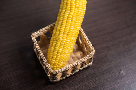 Corn in basket on wood background.の写真素材