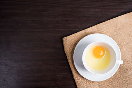 Fresh egg in white cup on cloth background.の写真素材