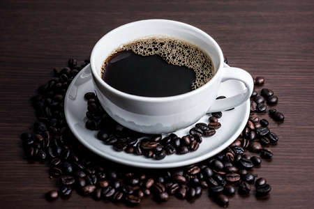 Black coffee in white cup and coffee bean on wood table background.の写真素材