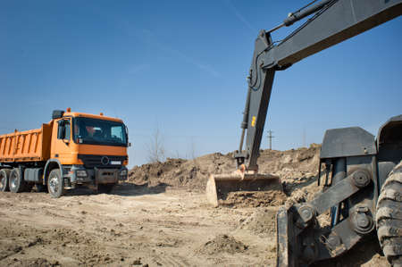 Hydraulic excavator and truck at work.の写真素材
