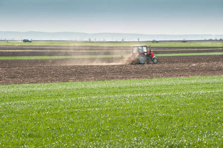 Tractor plowing the fields in springの写真素材