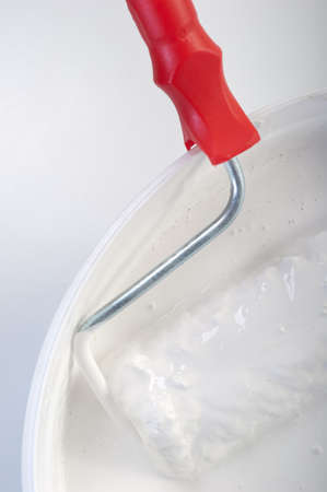 White paint with a roller in the bucketの写真素材