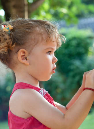 Profile of cute girl looking at it in the parkの写真素材