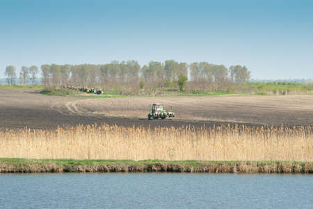 A tractor plowing and sowing in the fieldの写真素材