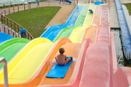 a happy boy falling into water in the aquaparkの写真素材