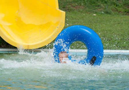 a happy boy falling into water in the aquaparkの写真素材