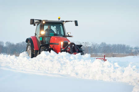 Tractor cleaning snow in fieldの写真素材