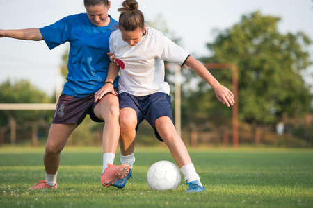 two female soccer players on the fieldの写真素材