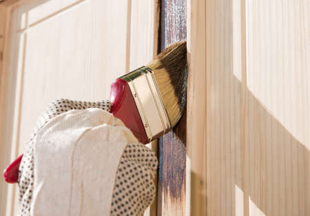 Maintaining of wooden surfaces with fresh protective paint.の写真素材