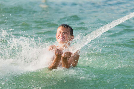 young happy child boy having fun in waterの写真素材