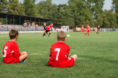 two reserve siiting out of football fieldの写真素材