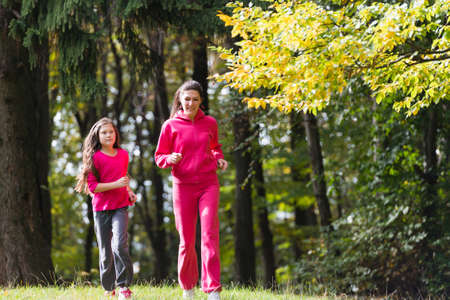 Two girls running on a meadowの写真素材