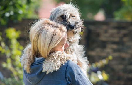 girl holding in arms her cute dog の写真素材