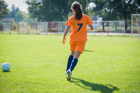 Teen Girl soccer player is kick soccer ballの写真素材
